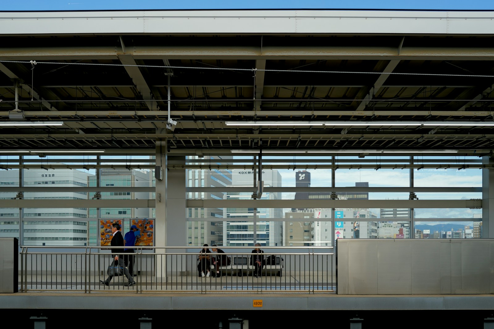 A train station with people walking on the platform